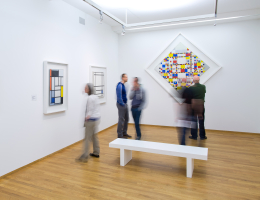 Mensen kijken naar de Victory Boogie Woogie van Mondriaan in Kunstmuseum Den Haag Mensen kijken naar de Victory Boogie Woogie van Mondriaan in Kunstmuseum Den Haag